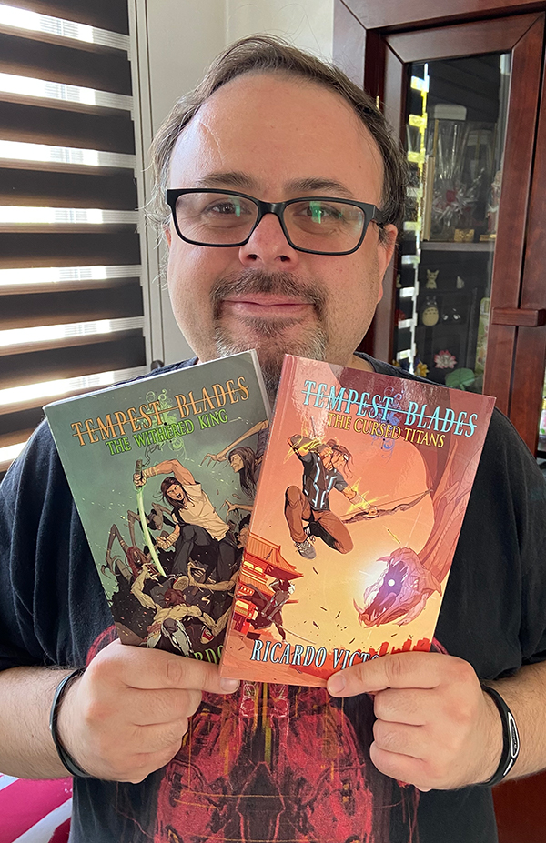 An image of Ricardo holding his Tempest Blades books